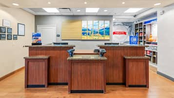 A reception area with wooden counters, a painting on the wall, and a 'Treats' sign.