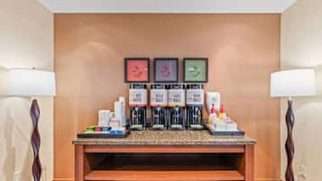 A coffee station with four dispensers labeled 'HOT WATER,' 'DECAF ROAST,' 'LIGHT ROAST,' and 'DARK ROAST.'