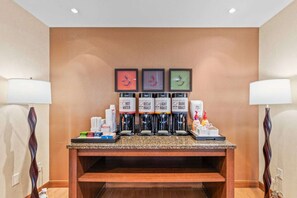 A coffee station with four dispensers labeled 'HOT WATER,' 'DECAF ROAST,' 'LIGHT ROAST,' and 'DARK ROAST.'