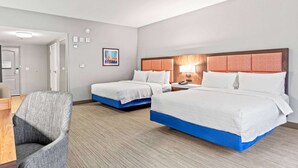 Una habitación de hotel con dos camas, un escritorio y una silla.