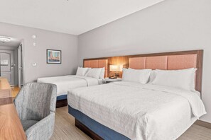 Una habitación de hotel con dos camas, un escritorio y una silla.
