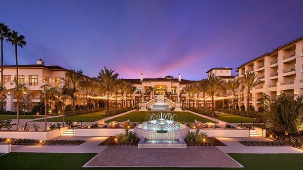 A hotel with a central fountain, symmetrical landscaping, and multiple balconies. - Steps to the Beach | Pool, Gym & Free Breakfast (Carlsbad)