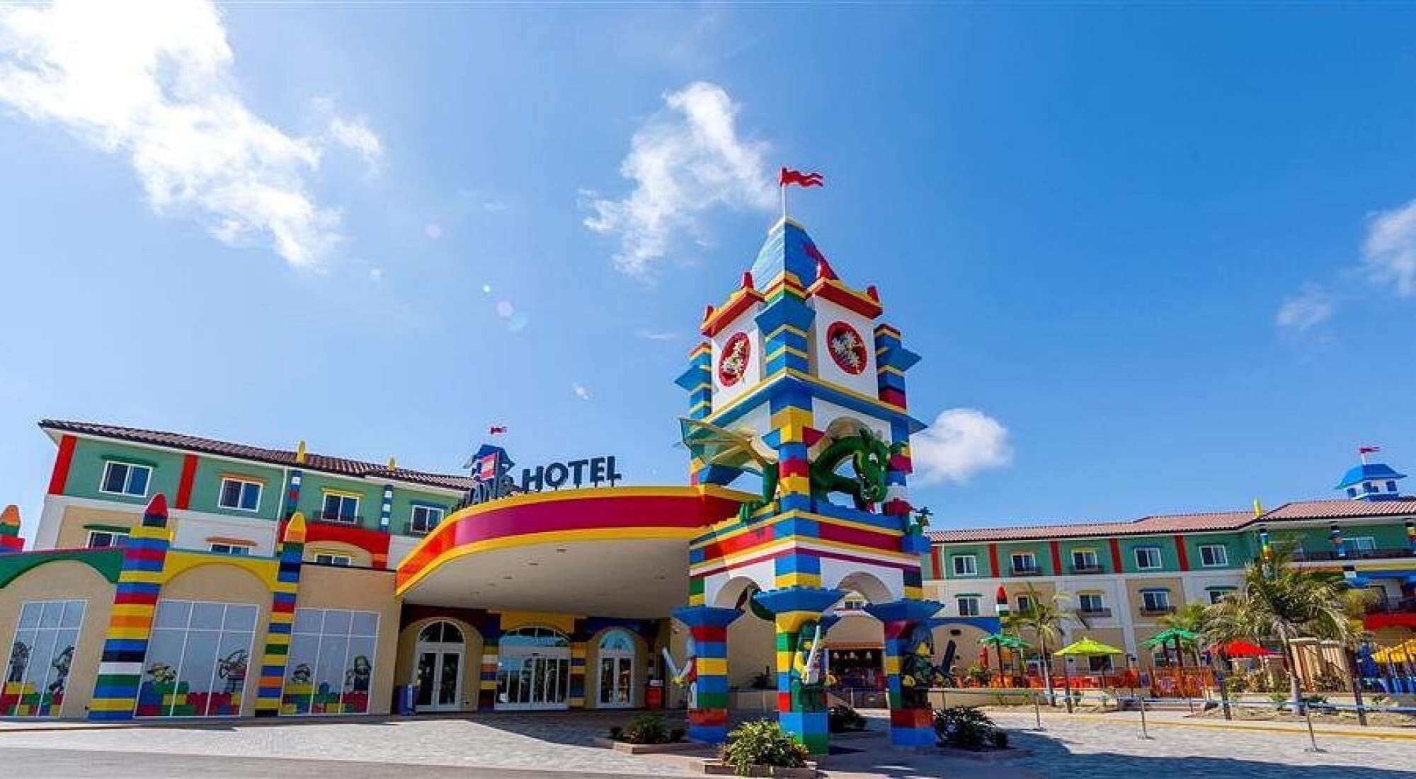 Ein farbenfrohes Hotel mit einem markanten Turm und einem Schild, auf dem "HOTEL" steht.