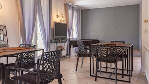 A dining area with a TV, chairs, and a table.