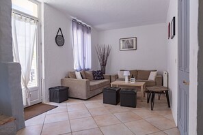 Una sala de estar con un sofá, una mesa de centro y una mesita de noche con una lámpara.