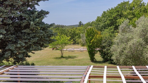 A view of a garden with a wooden pergola structure, a small tree, and a grassy area with a bench. - “Les Nougats” Room with Private Terrace, Shared Garden, and Wi-Fi (Portes-en-Valdaine)