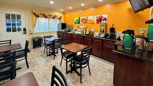 A hotel room with a dining area, a television mounted on the wall, and a window with curtains. - Near Lake Mendocino + Free Breakfast. Pool. (Ukiah)