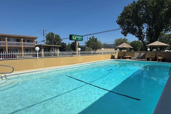 Clean swimming pool with signboard and loungers