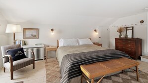 A bedroom with a bed, a chair, a dresser, and a lamp. - Gorgeous Hudson Valley Farmhouse On 14 Acres 3 Bedroom Home (Old Chatham)