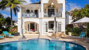 Ein zweistöckiges Haus mit Pool, Außenbereich und Balkon.