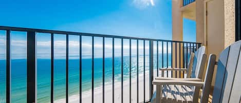 A balcony with a view of the ocean and beach.