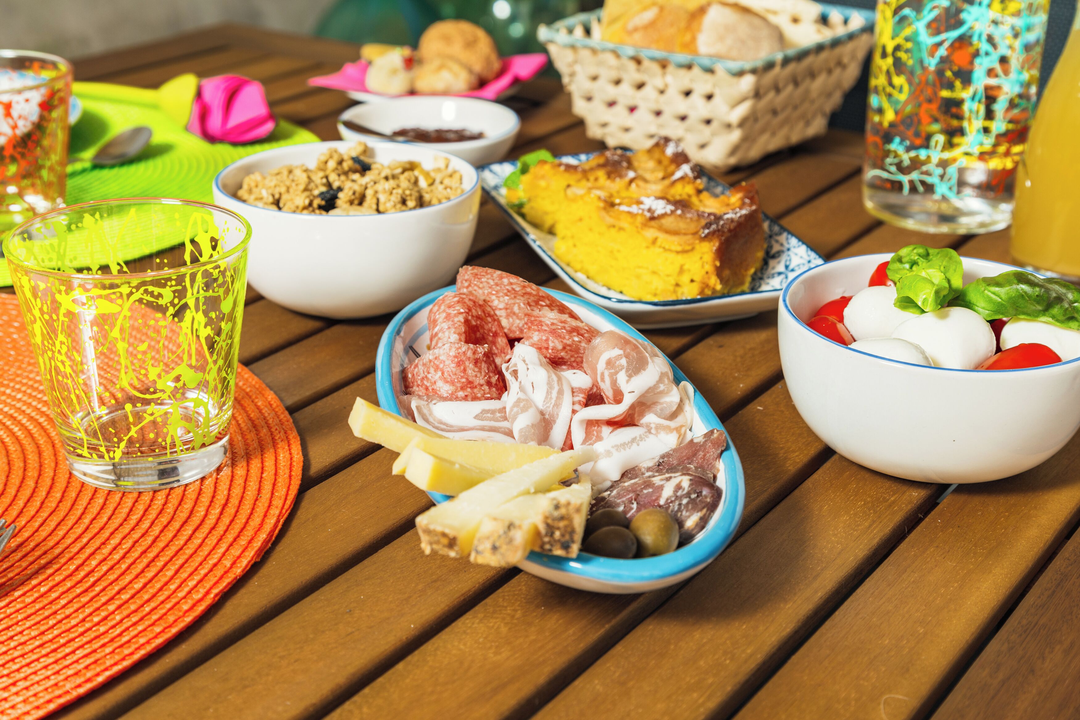 A table with various food items and a glass of yellow liquid.