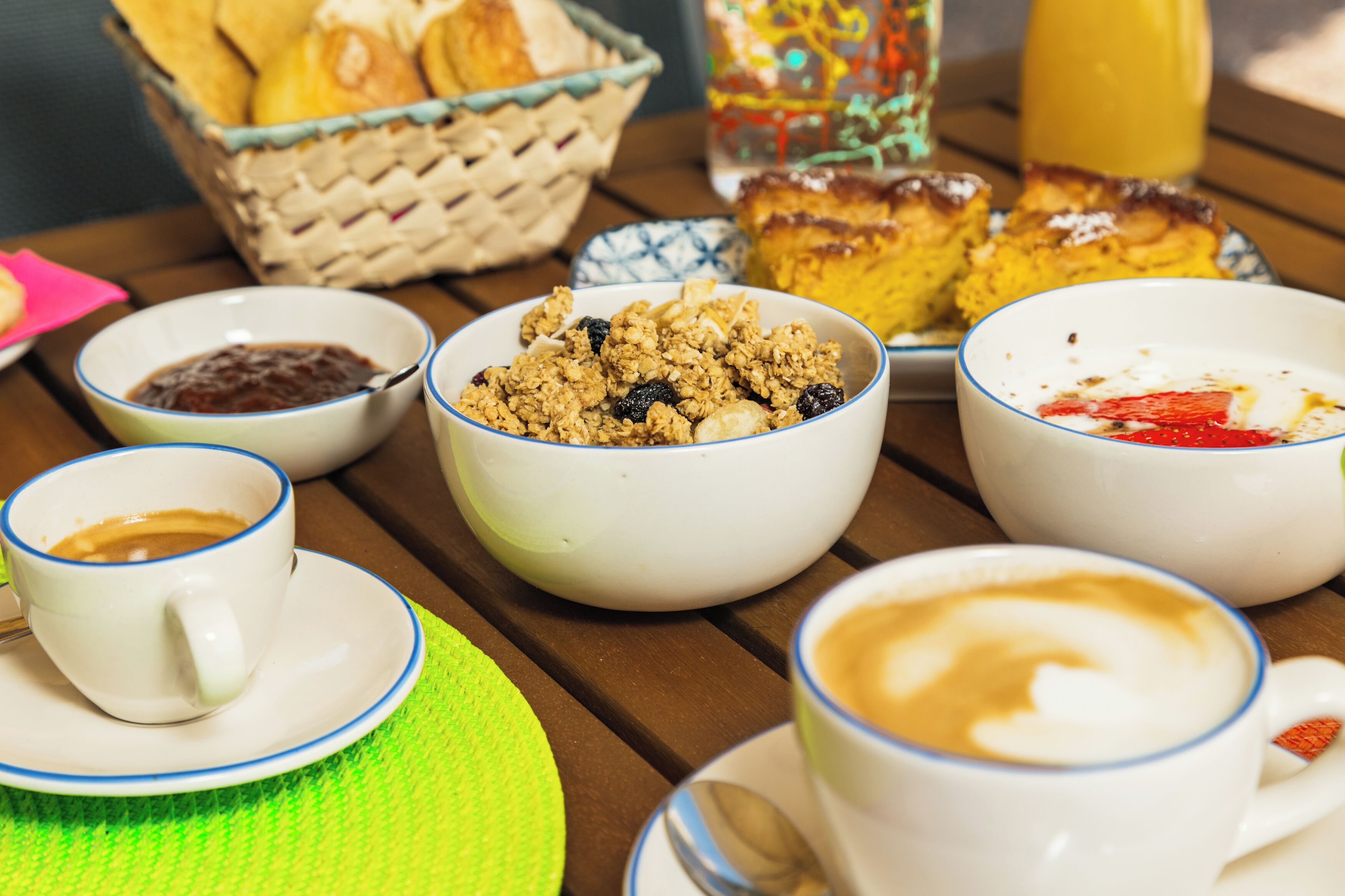 Una mesa de desayuno con diversas opciones de comida y tazas de café.