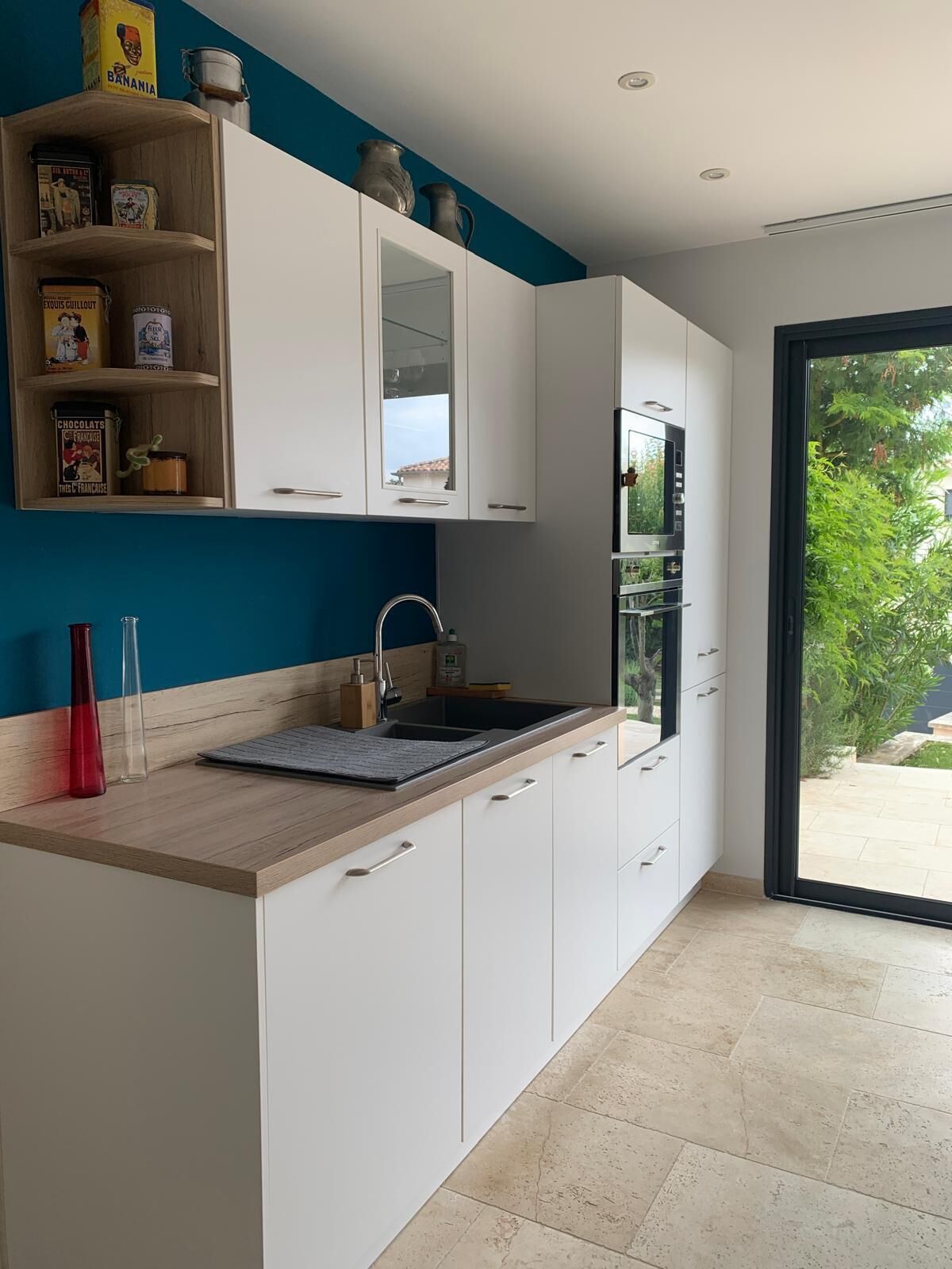 A modern kitchen with white cabinets, a wooden countertop, and a built-in oven.