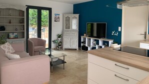 Una sala de estar moderna con un sofá, una mesa de centro de vidrio, un televisor y un mueble.
