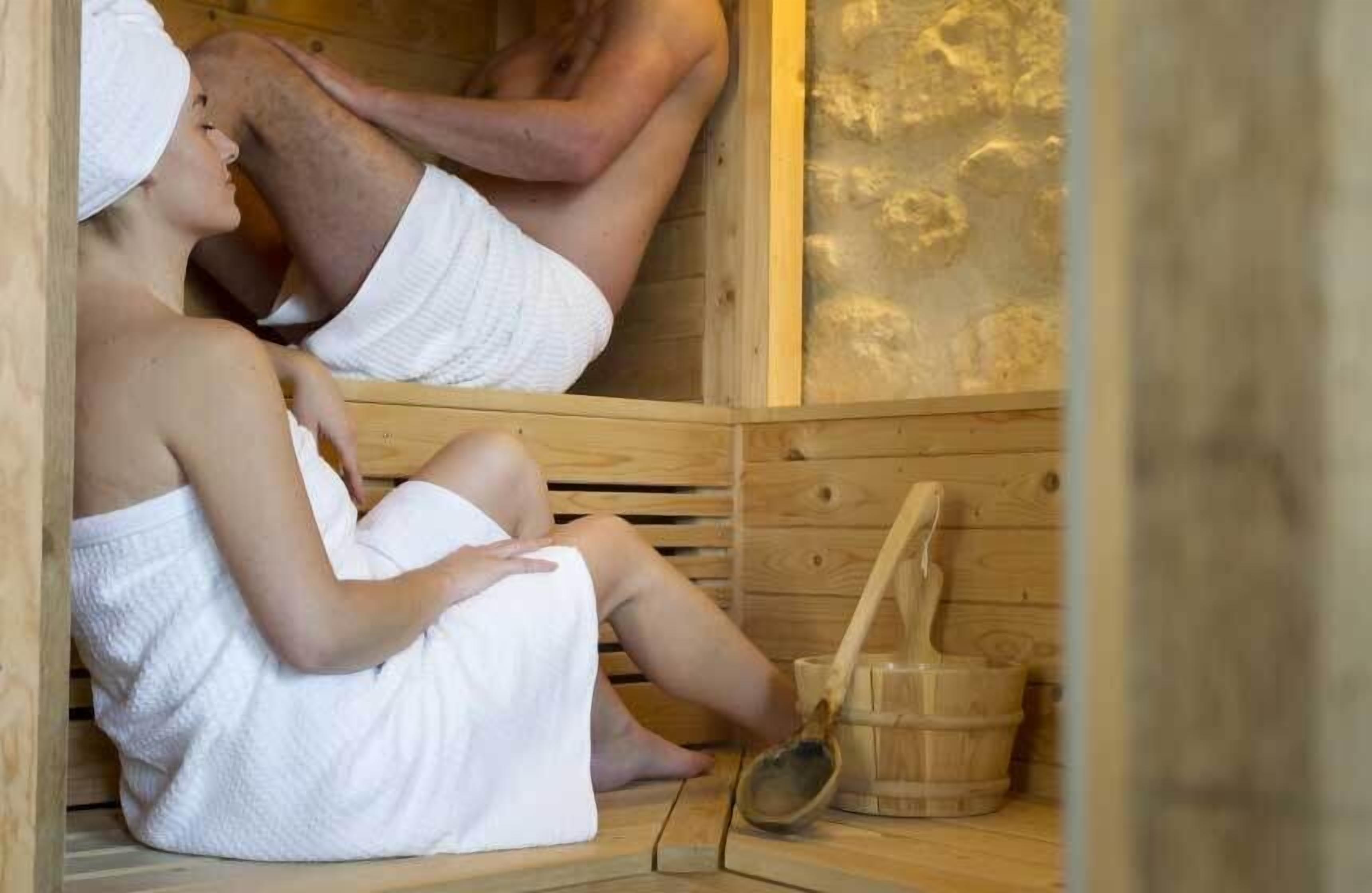 Eine Sauna mit Holzbänken und einem Holzfass.
