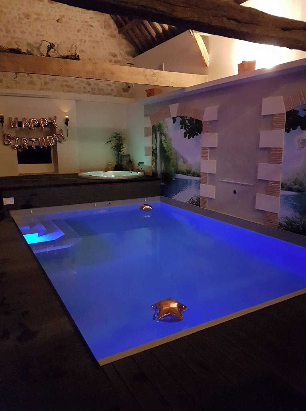A swimming pool with a blue floor and a 'Happy Birthday' balloon decoration.