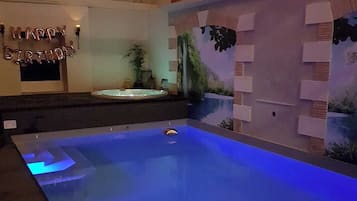 A swimming pool with a blue floor and a 'Happy Birthday' balloon decoration.