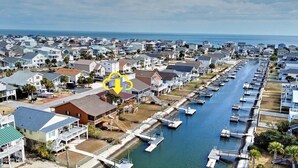 A coastal residential area with houses, a marina, and a water channel. - 3-bedroom canal home in delightful Ocean Isle Beach with boat dock. (Ocean Isle Beach)
