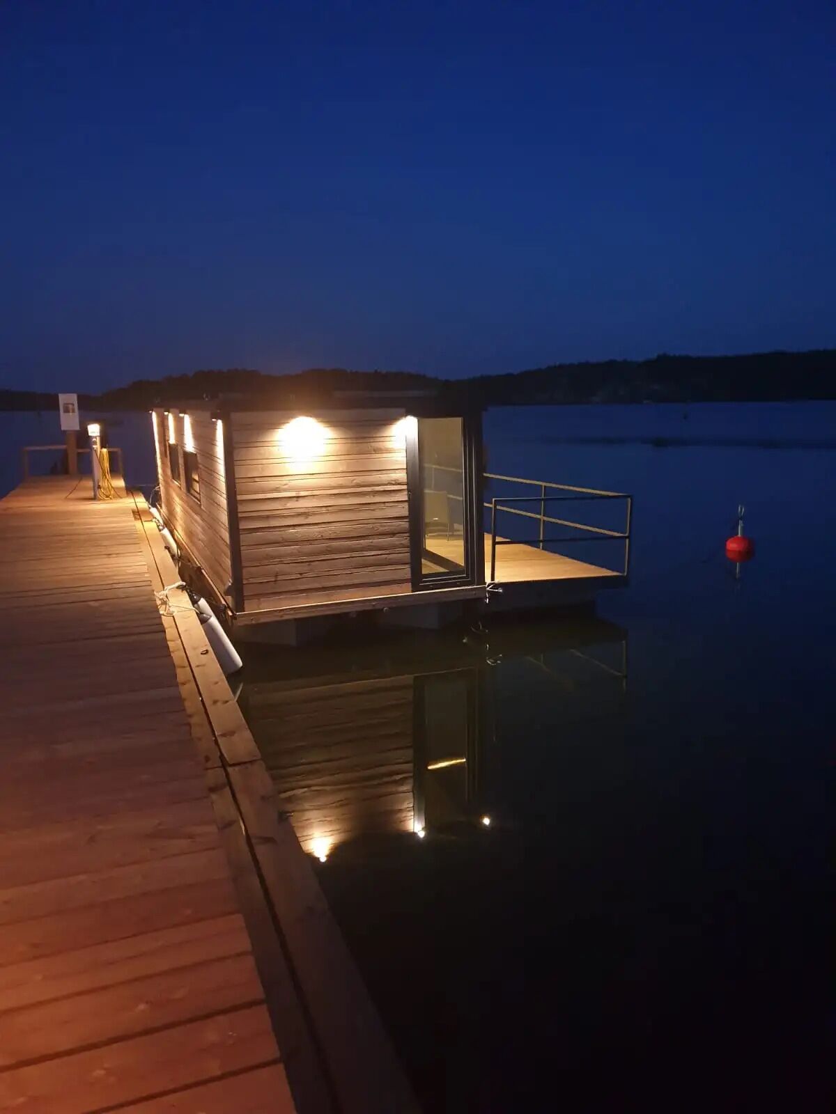 Une jetée en bois s’étendant sur une étendue d’eau calme, au crépuscule.