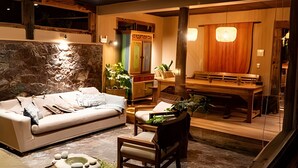 Una habitación acogedora con sofá, una mesa de madera y un banco.