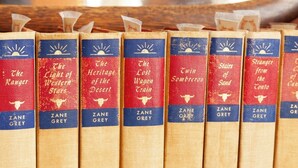 A collection of books with spines visible, each spine has a title and author's name. - Zane Grey - Historic Hotel Room (Cimarron)