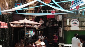 An outdoor dining area with tables and chairs, a pizza restaurant sign, and a building with a sign that reads "Barrucciere Spagnoli". - Cozy apartment in the heart of the Spanish quarters (Napoli)