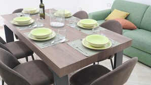 A dining table set with plates, glasses, and cutlery, surrounded by chairs. - Cozy apartment in the heart of the Spanish quarters (Napoli)