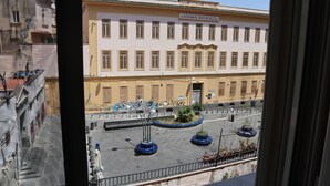 A building with a sign reading "Giovanni Paisello" and a courtyard with potted plants and a street lamp. - Cozy apartment in the heart of the Spanish quarters (Napoli)