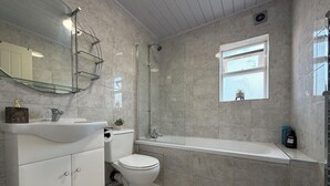 A modern bathroom with a toilet, sink, and bathtub.