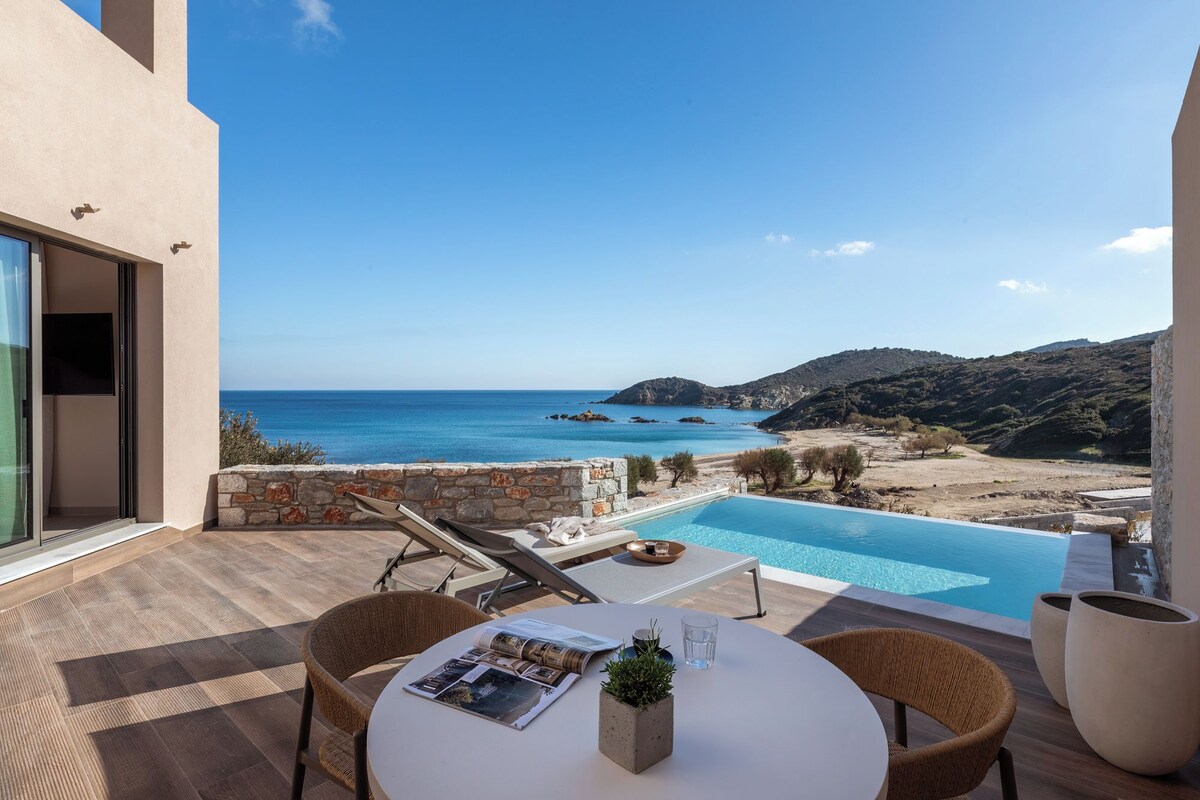 Un espace aménagé au bord de la piscine avec vue sur la mer, une table avec des magazines et une chaise.
