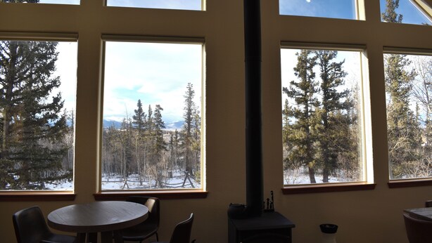 A room with large windows offering views of a snowy forest and mountains. - Sunflower Cabin • Modern Family Retreat • Easy Access • Pets OK • 1.2 Acres (Jefferson)