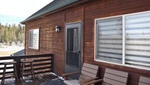 A wooden cabin with a porch, a bench, and two stools. - Sunflower Cabin • Modern Family Retreat • Easy Access • Pets OK • 1.2 Acres (Jefferson)