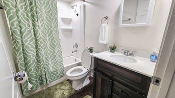 Een haardroger, handdoeken, zeep, toiletpapier