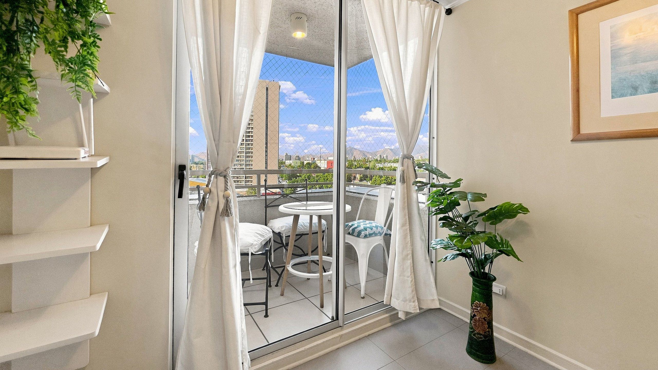A room with a sliding glass door leading to an outdoor area with a table and chairs.