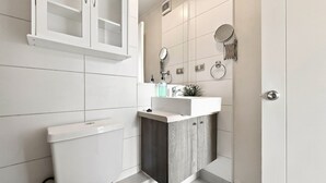 Une salle de bain moderne avec des toilettes, un lavabo et un miroir.
