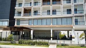 A multi-story hotel with a covered entrance, outdoor seating, and a sign reading 'CONCEPT LIFE STELLA 143'. - Concept Life Stella (Salvador)