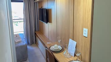 Un espace de repas moderne avec un mur en bois, un téléviseur à écran plat et une table dressée pour quatre personnes.