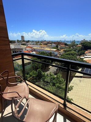 A balcony with a view of a cityscape, including buildings and a body of water. - Concept Life Stella (Salvador)