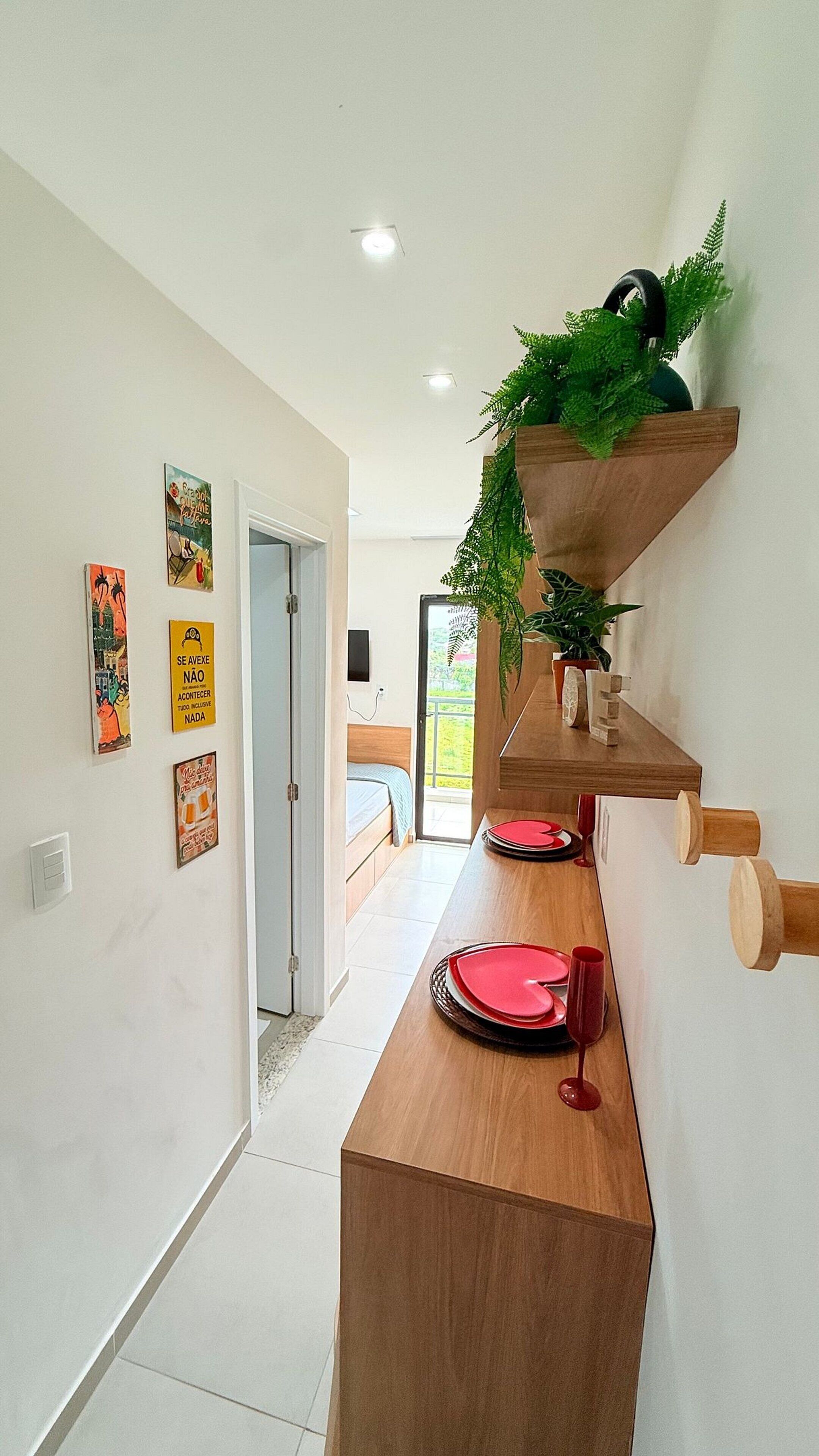 A modern interior with a wooden counter, decorative wall art, and a door leading to a balcony.