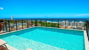 Piscina infinita en la azotea con vistas despejadas al océano y al paisaje urbano.