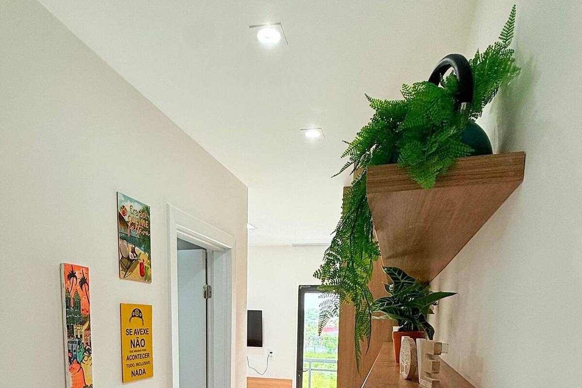 Un interior moderno con una encimera de madera, detalles decorativos en la pared y una puerta que da a un balcón.