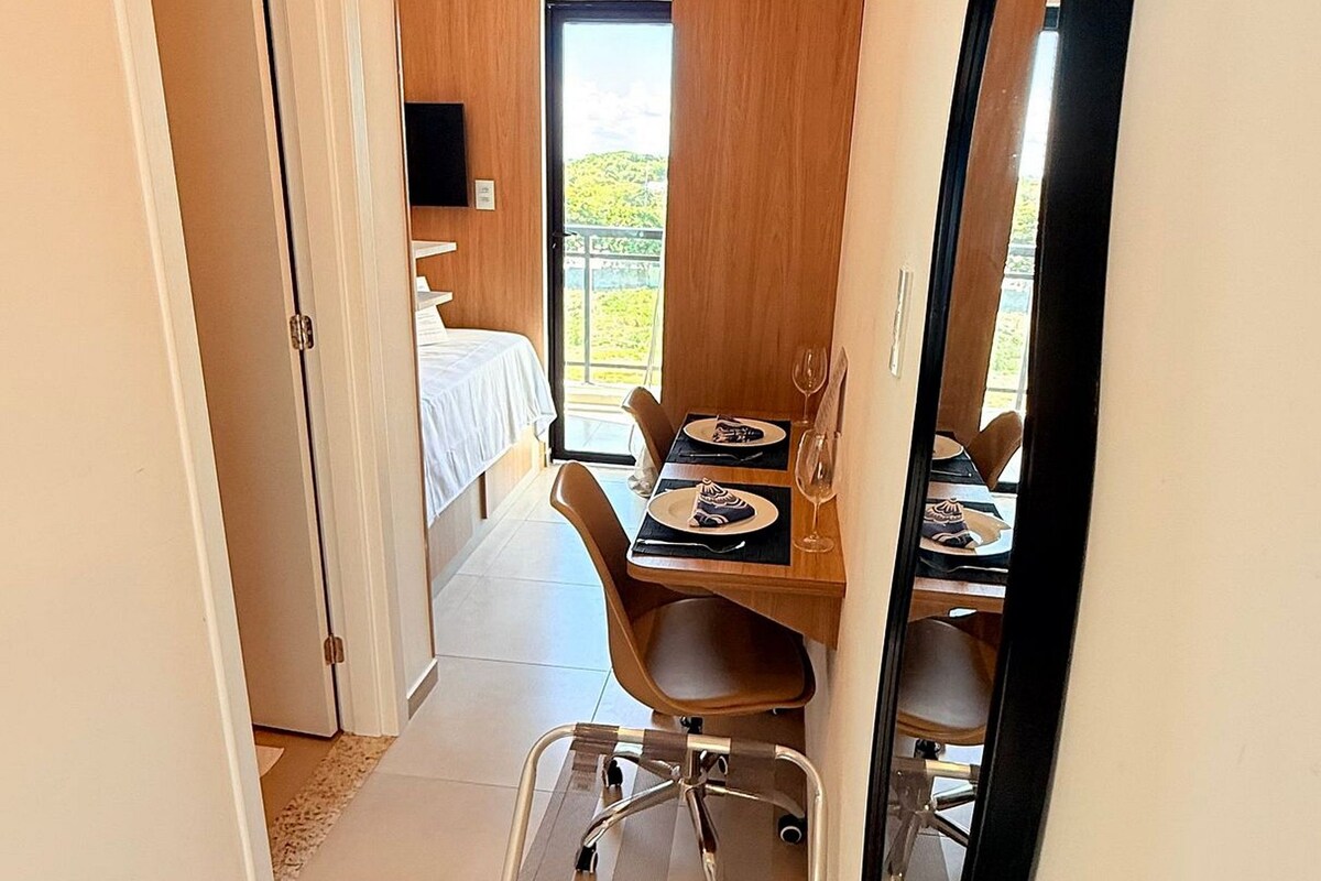 A hallway leading to a dining area with a table set for two, a chair, and a wheeled cart.