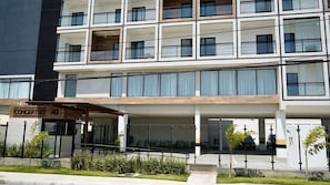 A multi-story hotel with a covered entrance, outdoor seating, and a sign reading 'CONCEPT LIFE STELLA 143'. - Concept Life Stella (Salvador)
