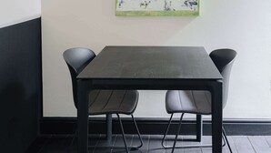 A dining area with a table and two chairs, a pegboard on the wall, and a floor with a black and white pattern. - Bright & Cozy Studio in Mechelen (Mechelen)