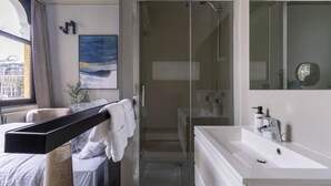 A modern bathroom with a shower, a large sink, and a mirror. - Elegant Balcony Suite (Antwerpen)