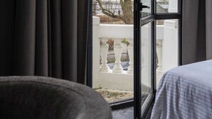 A room with a bed, a stone bowl, and a large window with curtains. - Elegant Balcony Suite (Antwerpen)