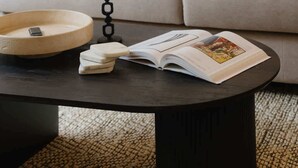 A living room with a sofa, cushions, a coffee table, a book, and a candle holder. - Stylish Duplex Getaway in the Heart of Antwerp (Antwerpen)