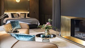 A modern living room with a sofa, a round coffee table, and a fireplace. - Luxurious Elegant Timeless Suite (Antwerpen)