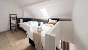 Ein modernes Schlafzimmer mit zwei Betten, einem Oberlicht und Holzboden.